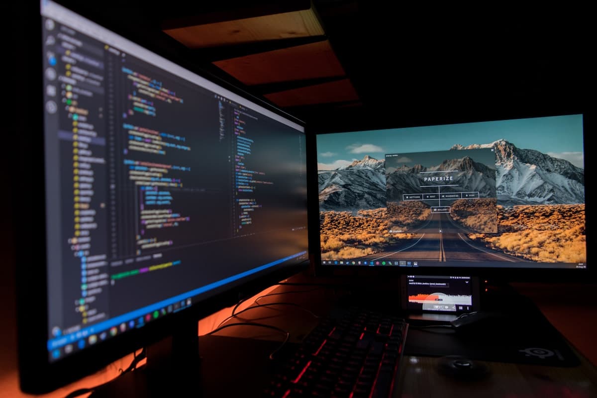 Dual-screen workstation running code in a dark room